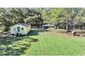 Aerial view of a yellow house with a large yard and detached garage at 1860/1858 Taberwood Cir, Charleston, SC 29407