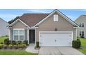 Tan house with white garage door and landscaping at 126 Harbor Trace Ln, Summerville, SC 29486