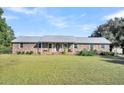 Brick ranch house with metal roof and landscaped yard at 203 Hickory Nut Drive, Harleyville, SC 29448