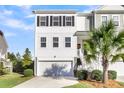 Two-story townhome with white and gray siding, a garage, and a palm tree at 681 Mclernon Trce, Johns Island, SC 29455