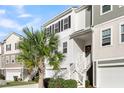 Two-story townhome with white and gray siding, a garage, and a palm tree at 681 Mclernon Trce, Johns Island, SC 29455