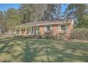 Brick ranch house with a covered porch and well-manicured lawn at 1839 Manigault Pl, Charleston, SC 29407