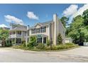 Tan house with a porch, landscaping, and detached garage at 1751 Bee Balm Rd Rd, Johns Island, SC 29455