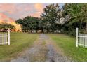 Gravel driveway entrance with white picket fence leading to a home at 1109 Pinefield Dr, Wando, SC 29492
