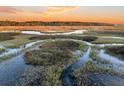 Aerial view of tranquil marsh at sunset with calm waters at 1109 Pinefield Dr, Wando, SC 29492
