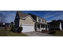Two-story house with a white garage door and a landscaped yard at 1450 Coopers Hawk Dr, Hanahan, SC 29410