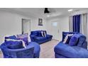 Bright living room with blue velvet sofas and light wood floors at 2748 E Surrey Dr, North Charleston, SC 29405