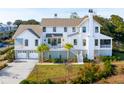 White farmhouse style home with gray metal roof and expansive lawn at 9004 Topwater Ln, Johns Island, SC 29455