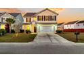 Two-story house with a beige exterior, a white garage door, and a landscaped front yard at 108 Glenspring Dr, Summerville, SC 29486