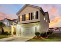 Two-story house with a beige exterior, a white garage door, and a landscaped front yard at 108 Glenspring Dr, Summerville, SC 29486