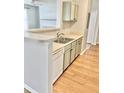 Kitchen features a breakfast bar, double sink, and light sage cabinets at 45 Sycamore Ave # 1236, Charleston, SC 29407