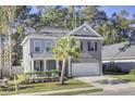 Two-story home with gray brick and white trim, featuring a front porch and attached garage at 700 Kilarney Rd, Summerville, SC 29483