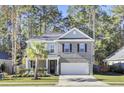 Two-story home with gray brick and white trim, featuring a front porch and attached garage at 700 Kilarney Rd, Summerville, SC 29483