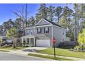 Two-story home with gray brick and white trim, featuring a front porch and attached garage at 700 Kilarney Rd, Summerville, SC 29483