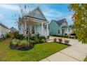 Light blue house with a well-manicured lawn and inviting front porch at 104 True Blue, Summerville, SC 29486
