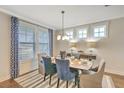 Elegant dining room with hardwood floors, blue chairs, and a stylish light fixture at 137 Winding Grove Ln, Moncks Corner, SC 29461
