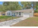 Newly painted grey brick ranch home with a blue door, and a well-manicured lawn at 3264 Stonehaven Dr, North Charleston, SC 29420