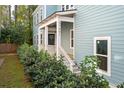 Front entrance of a charming home with white porch and landscaping at 5748 Pilgrim Ave # D, Hanahan, SC 29410
