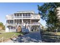 Three-story beach house with multiple decks and a paved driveway at 3611 Yacht Club Rd # B, Edisto Island, SC 29438