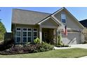 Landscaped yard with a spacious two-car garage and a welcoming porch at 404 Claymoor Village Ln, Summerville, SC 29486