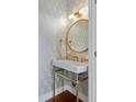 Elegant powder room with patterned wallpaper, round mirror, and pedestal sink at 780 Post Oak Dr, Mount Pleasant, SC 29464