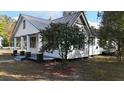 White cottage with black accents and a blooming camellia bush at 203 Padgett Loop, Walterboro, SC 29488