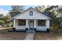 Charming white cottage with black trim, metal roof, and covered porch at 203 Padgett Loop, Walterboro, SC 29488