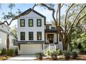 White two-story house with dark trim, a large tree, and landscaping at 2715 Old Oak Walk, Seabrook Island, SC 29455