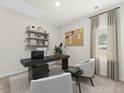 Home office with a black desk, floating shelves, and two comfortable armchairs at 316 Calm Water Way, Summerville, SC 29486