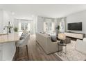 Open living space with hardwood floors, a beige sofa, and a kitchen island at 316 Calm Water Way, Summerville, SC 29486