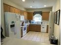 Galley kitchen with wood cabinets, tile floor and white appliances at 4600 Palm View Cir, North Charleston, SC 29418