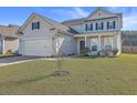 Two-story house with beige siding, white garage door, and manicured lawn at 488 Sanctuary Park Dr, Summerville, SC 29486