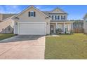 Two-story house with beige siding, white garage door, and manicured lawn at 488 Sanctuary Park Dr, Summerville, SC 29486