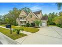 Brick home with a two-car garage and nicely landscaped lawn at 1068 Blockade Runner Pkwy, Summerville, SC 29485