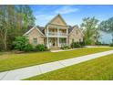 Two-story brick home with a front porch and well-maintained landscaping at 1068 Blockade Runner Pkwy, Summerville, SC 29485