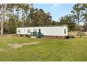 Side view of the mobile home showcasing its length and yard at 113 Hill Drive, Summerville, SC 29483