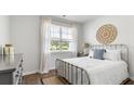 Bedroom with metal bed frame, wood flooring, and window with blinds at 136 Lilac Grove Way, Summerville, SC 29486