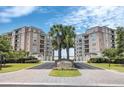 Elegant condo building entrance with palm trees and landscaping at 221 S Plaza Ct # 107, Mount Pleasant, SC 29464
