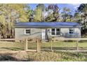 Brick ranch home with a metal roof, fenced yard, and wood gate at 1243 Pineville Cir, Pineville, SC 29468