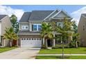 Two-story brick home with gray roof, palm trees, and a large driveway at 192 Lindera Preserve Blvd, Summerville, SC 29486