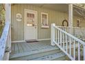 White-railed porch with rocking chairs and a charming cottage entrance at 4401 Prices Bridge Ln, Walterboro, SC 29488