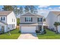 Gray siding two-story house with a white garage door and landscaping at 314 Black Birch Dr, Summerville, SC 29486