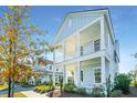 Two-story light blue house with a white porch and balcony, surrounded by landscaping at 389 Watergrass Way, Summerville, SC 29485