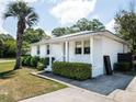 White brick ranch house with a metal roof, landscaped yard, and palm tree at 509 Live Oak Dr, Mount Pleasant, SC 29464