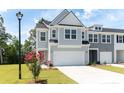 Two-story townhome with gray siding, white garage door, and landscaping at 569 Trotters Ln # 222, Moncks Corner, SC 29461