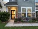 Well-lit front entryway with stone accents and landscaping at 1011 Mossy Rock Dr, Summerville, SC 29485