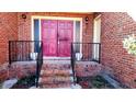 Brick front porch with double pink door and black railing at 153 Davis Ter, Saint George, SC 29477