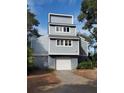 Two-story home with attached garage and landscaped yard at 32 Marsh Island (4 Shares) Ln, Isle of Palms, SC 29451