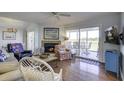 Cozy living room with fireplace, hardwood floors, and access to deck at 32 Marsh Island (4 Shares) Ln, Isle of Palms, SC 29451