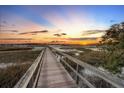 Wooden walkway over marsh leading to sunset view at 122 Cainhoy Landing Rd, Charleston, SC 29492